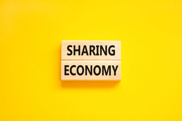 Sharing economy symbol. Concept words Sharing economy on beautiful wooden blocks. Beautiful yellow table yellow background. Business sharing economy concept. Copy space.