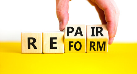 Reform and repair symbol. Concept words Reform Repair on wooden block. Beautiful yellow table white...