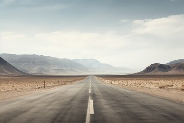 An empty road cutting through a stark, arid desert landscape