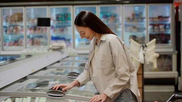 A woman shopping for fresh fish salmon in supermarket retail store