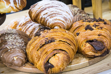 Croissant with chocolate and powder sugar on market stall or in confectionery shop