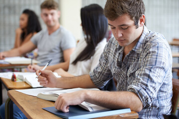University, book and man in class reading with ambition for development in learning, opportunity and future. Education, knowledge and growth for college student in lecture, studying for exam or test.