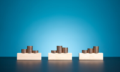 Stack of coins on blank wooden blocks for your words with blue background. Investment asset...