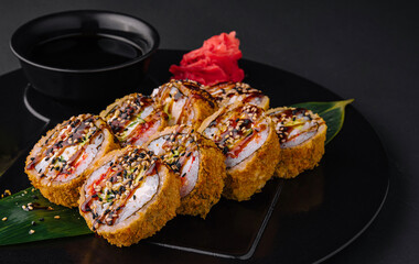 Served warm sushi with ginger and wasabi on a black stone plate