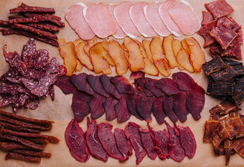 various jerky or dried meats and sausage on a board