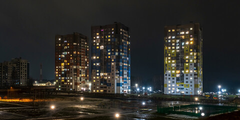 Fototapeta na wymiar with light in windows of multistory buildings at night. life in a big city. Serenade of light
