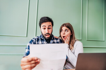 Stressed young couple checking bills, taxes and bank account balance at home  - Family at panicking...