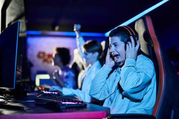 focus on cheerful young woman winning game next to diverse female friends, cybersport gamers