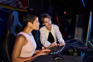 Fototapeta na wymiar two women focused on a cybersport gaming session, female players thinking on game strategy