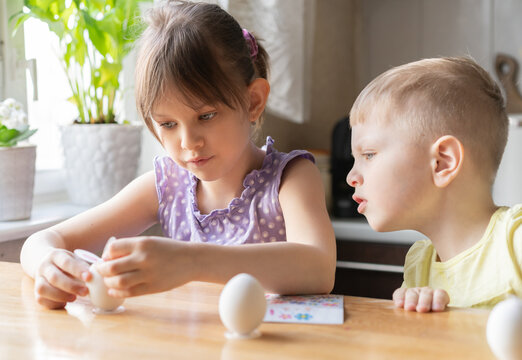 Little girl decorate easter eggs at home. Preparing for Easter concept. Selective Focus