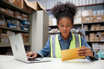 factory worker reading and looking at envelope in the office or warehouse storage