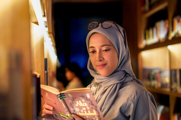 Happily young muslim woman enjoying books at the library. library concept