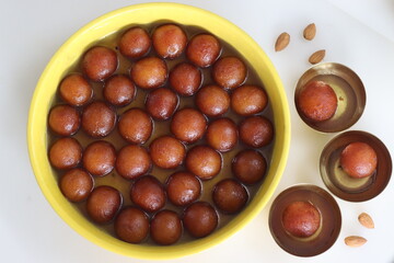 Delectable Gulab Jamun dessert on a rustic plate. Close up of golden fried milk balls in sweet syrup