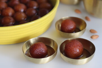 Delectable Gulab Jamun dessert on a rustic plate. Close up of golden fried milk balls in sweet syrup