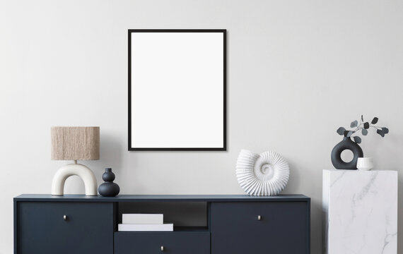 Blank picture frame mockup on wall in modern minimalist interior. Artwork template mock up in scandinavian interior design. Home staging and minimalism concept