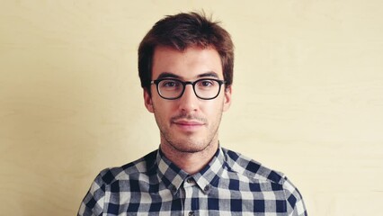 Face, nerd and man with glasses, eyesight and vision with stylish outfit on a studio background. Portrait, geek and model with eyewear and frames with a shirt, trendy clothes and mockup space