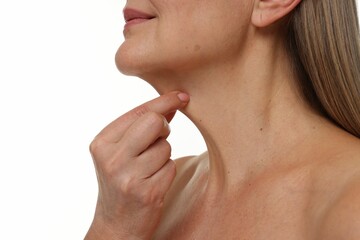 Obraz premium Mature woman touching her neck on white background, closeup