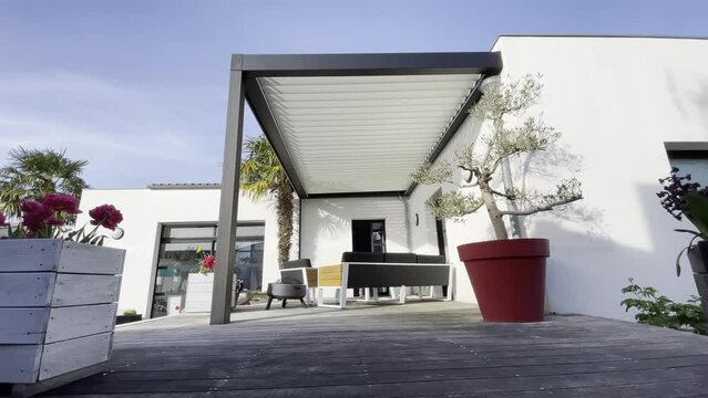 Trendy outdoor patio pergola shade structure, awning and patio roof, garden lounge, chairs, metal grill surrounded by landscaping