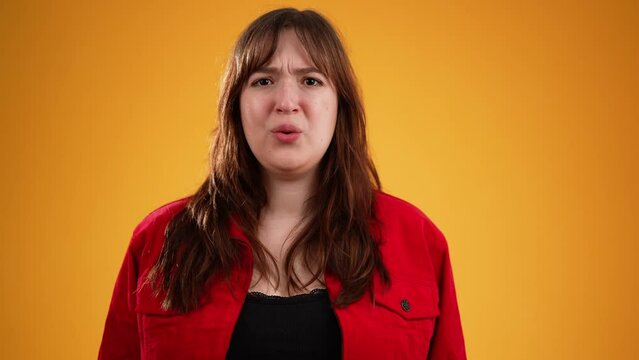 Young smiling good kind surprised happy woman 20s wear red jacket ask who me oh it so sweet put hands on chest isolated on yellow background studio portrait. People lifestyle concept