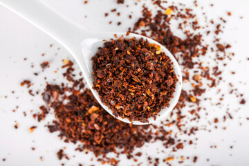 Close-up of red pepper or chili powder in a white ceramic spoon