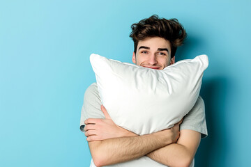 Young man hugging his pillow, sleeping like baby, enjoying sweet dreams, feeling relaxed, over blue wall