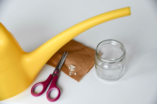 Nematoden gegen Trauerm&uuml;cken auf braunem Papier und Schere, Giesskanne und Gl&auml;schen