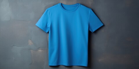 Blue t shirt is seen against a gray wall