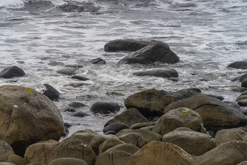 Lively sea water between large rolling rocks.