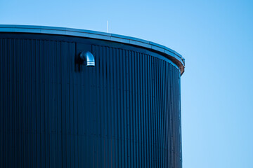 Top of a tall round grey metal tank.