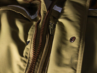 Zipper on beige workwear protective clothing in close-up.