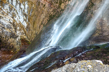 Waterfall with colorful rock wall in Nacimiento del Rio Mundo in Spain