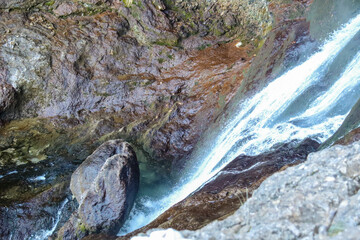 Waterfall with colorful rock wall in Nacimiento del Rio Mundo in Spain