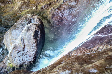 Waterfall with colorful rock wall in Nacimiento del Rio Mundo in Spain