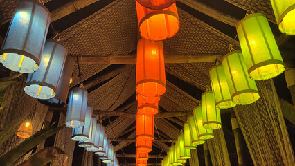 City lights and red lanterns illuminate the park amidst Japanese or Chinese architecture
