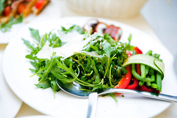 Plate of salad with arugula tomatoes peppers cheese and arugla