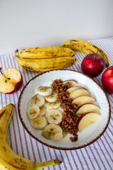 Healthy breakfast with natural yogurt, granola, apple and bananas