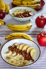 Zdrowe śniadanie z jogurtem naturalnym, granolą, jabłkiem i bananami