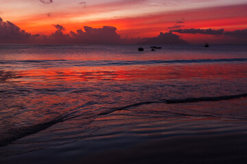 Fototapeta na wymiar Ocean shore water under colorful sunset sky. Mahe island, Seychelles