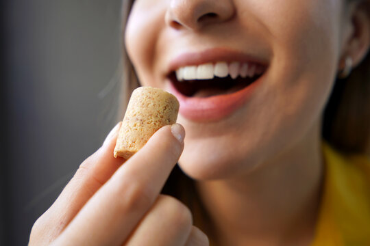 Peanut candy (pa&ccedil;oca or pacoca). Extreme close-up of beautiful girl eating Pacoca traditional Brazilian peanut-based candy.