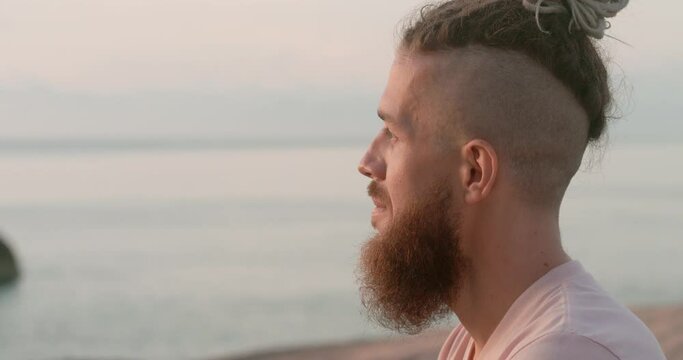 Side view of man on beach close-up immersed in thoughtfulness background sea Thoughtfulness amidst tranquil weather. Thoughtfulness harmonizing with sunset Essence of healthy living.