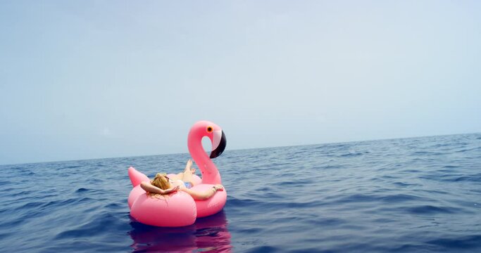 Relax, floating or woman at beach on holiday, summer vacation or break in Italy for peace alone. Female person, chilling or lady on inflatable flamingo for tropical travel, water or paradise at sea