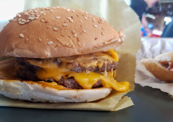 Close up view for meat cheese meat burger in it is paper