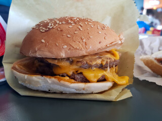 Close up view for meat cheese meat burger in it is paper