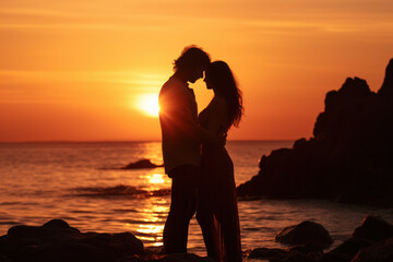 Fototapeta premium Romantic couple silhouette embracing at sunset on beach. Love and relationships.