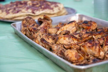 grilled Chicken tray ready to be eaten with people hands and musakhan bread