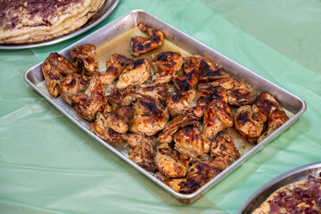 grilled Chicken tray ready to be eaten with people hands and musakhan bread