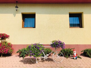 Garden decorated with summer flowers and bicycles 