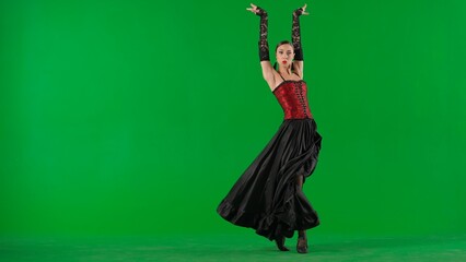 Woman dancer dancing on chroma key green screen. Female in flamenco style dress performs elegant...