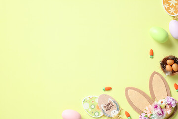 Flat lay composition with Easter eggs, bunny ears, decorations on pastel green background. Happy Easter concept.
