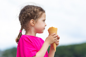 Portrait of a cute girl with ice cream on a walk in the park. child outdoors